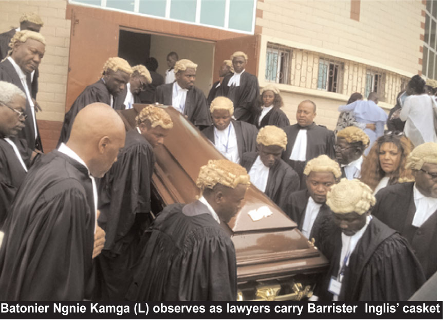 Batonier Ngnie Kamga (L) observes as lawyers carry Barrister Inglis’ casket