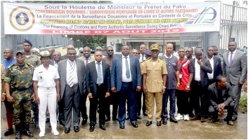 Participants pose with administrators in front of custom office Limbe
