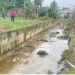 A flooded drainage canal in Douala, illustrating the chronic waterlogging the PVGFD project aims to address.